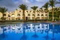 Swimming pool with the some beach lounges with a view on green palms Royalty Free Stock Photo