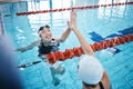 Swimming pool, sports and women high five in water for teamwork, collaboration or solidarity. Swimmer, happiness and