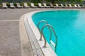 swimming pool with stainless handrail stair and sunbathing beds Royalty Free Stock Photo