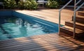 Swimming pool with stair and wooden deck at hotel. Royalty Free Stock Photo