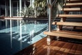 Swimming pool with stair and wooden deck at hotel. Royalty Free Stock Photo