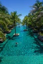 Swimming pool surround with coconut tree and bangalows at seaside resort Royalty Free Stock Photo