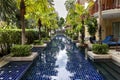 Swimming pool surrounded by a beautiful park of palm trees at the Phuket Graceland resort and spa hotel in Patong Royalty Free Stock Photo