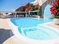 Swimming pool on terrace in traditional white cave house on Santorini