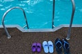 Swimming pool. Three pairs of rubber slippers standing next to each other - men`s, women`s and children`s. Family subscription Royalty Free Stock Photo