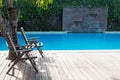 Swimming pool with two empty chairs Royalty Free Stock Photo