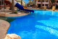 Swimming pool with water slide at tropic summer resort Royalty Free Stock Photo