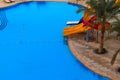 Swimming pool with water slide at tropic summer resort. View from above Royalty Free Stock Photo