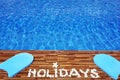 Swimming pool water with text holidays made of white stone Royalty Free Stock Photo