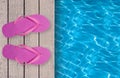 Swimming pool, wooden deck and pink beach shoes