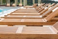 Swimming pool with wooden sunbeds. Royalty Free Stock Photo