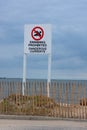 Swimming Prohibited Dangerous Currents warning sign at ocean beach shoreline