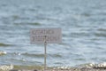 Swimming is prohibited. The inscription on the plate by the sea. There is nobody on the beach