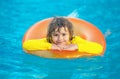 Swimming, summer vacation. Child swim in pool on inflatable ring. Kid with inflatable ring in swimming pool. Summer