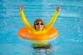 Swimming, summer vacation. Cute child playing in blue water. Kid enjoying summer vacation in water in the swimming pool