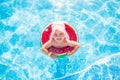 Swimming, summer vacation - lovely smiling girl in pink hat playing in blue water with lifebuoy-watermelon Royalty Free Stock Photo