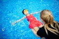 Swimming trainer woman instructing kid girl in pool, concept swimmer children