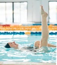 Swimming, woman and legs up in water, ballet exercise and training for healthy body. Pool, feet and happy athlete in