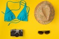 Swimsuit, hat, camera, sunglasses on a yellow background Royalty Free Stock Photo