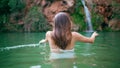 Swimsuit model swimming fjord back view. Woman floating in deep emerald lagoon Royalty Free Stock Photo