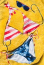 Swimsuit and sunglasses striped american flag placed on yellow cloth
