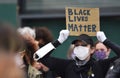 A young female BLM protester with a sign that reads ` Black Lives Matter`