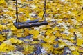 Swing in autumn leaves Royalty Free Stock Photo