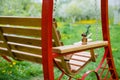 Swing bench near children house in garden.