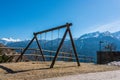 Swing, child`s playground, mountain view, snow covered Alps mountains