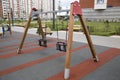 Swing children`s wooden supports on the Playground in the city outdoors Royalty Free Stock Photo