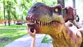 A close-up of a full-length mini Tyrannosaurus Rex. Reconstruction of extinct species. Swing for children. Styling extinct animals