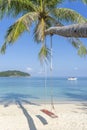 Swing hang from coconut palm tree over sand beach near blue sea water in Thailand. Summer, travel, vacation and holiday concept Royalty Free Stock Photo