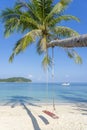 Swing hang from coconut palm tree over sand beach near blue sea water in Thailand. Summer, travel, vacation and holiday concept Royalty Free Stock Photo