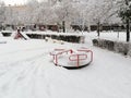 Swing on the playground in the city park in the snow. Paintpage winter. Royalty Free Stock Photo