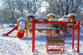 Swing and playground covered with snow