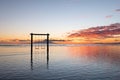 Swing on seashore during the sunrise. Sky and reflections on the water in the summer. Nusa Penida, Bali, Indonesia.