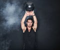 Swinging his way to strong. Studio shot of a young man working out with a kettle bell against a gray background.