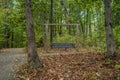 Swinging park bench in the woods Royalty Free Stock Photo