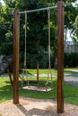 The swings hung below the brick floor. Children playground ayunan swing hanging in park garden. blank white wooden swing in flower Royalty Free Stock Photo