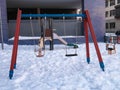 Swings in a playground covered by snow Royalty Free Stock Photo