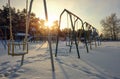 Swings at the playground covered with snow in winter time. Royalty Free Stock Photo