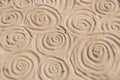 Swirl pattern on the sand. Hand drawn swirls on the sandy beach