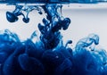 Swirling blue ink diffusing into clear water creates intricate patterns and fluid shapes. The Royalty Free Stock Photo