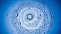 Swirling pattern of water droplets on blue surface creating a cosmic vortex effect Royalty Free Stock Photo