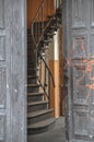 Swirly winding stairs visible behind the open old door of the tenement house Royalty Free Stock Photo