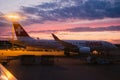 Swiss airline airplane parked in airport during dramatic cloudy summer sunset as seen from inside plane