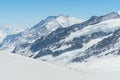 Swiss Alps mountain range landscape full of snow in winter, with group of traveler trekking to summit