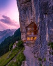 Swiss Alps and a mountain restaurant under the Aescher cliff viewed from mountain Ebenalp in the Appenzell region in Royalty Free Stock Photo