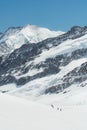 Swiss Alps mountain range landscape full of snow in winter, with group of traveler trekking to summit