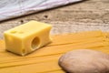 Swiss cheese and pasta on a wooden background